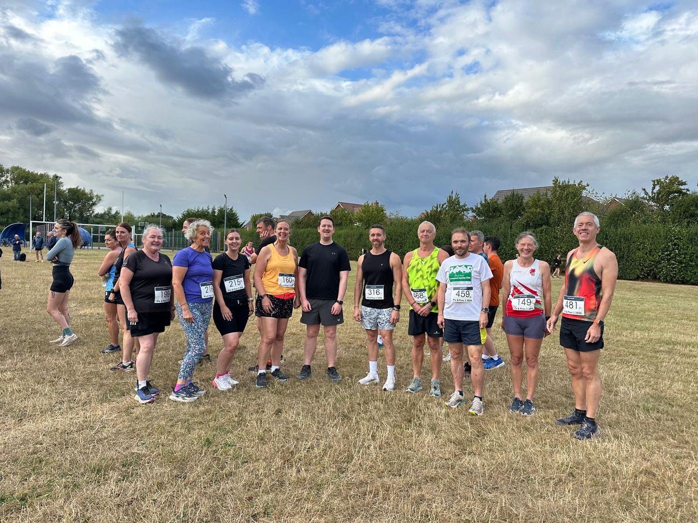 Group of club runners gathered on grass before a run